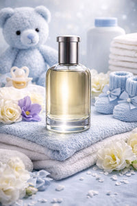 Baby-themed setting with a bottle of perfume, teddy bear, and baby items on a soft surface.