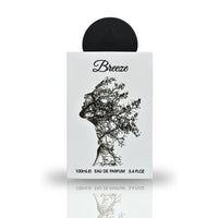 A close-up view of the Breeze Eau De Parfum bottle by Lattafa Pride, featuring an artistic design of a silhouette intertwined with branches on a sleek white surface.