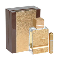 A luxurious bottle of Haramain Amber Oud Gold 999.9 Dubai Edition Extrait De Parfum, 100ml, displayed alongside its elegant gold-textured packaging and an additional atomizer.
