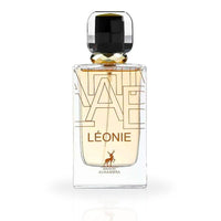 A close-up of the Léonie Eau De Parfum bottle by Maison Alhambra, showcasing its sleek glass design with golden accents and a luxurious black cap.